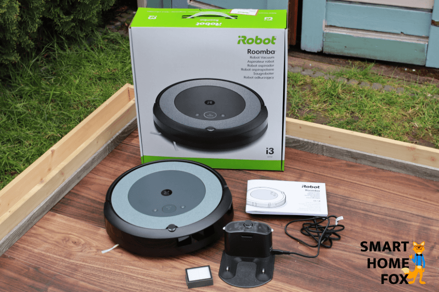 Der gesamte Lieferumfang des iRobot Roomba i3 steht auf dem Boden